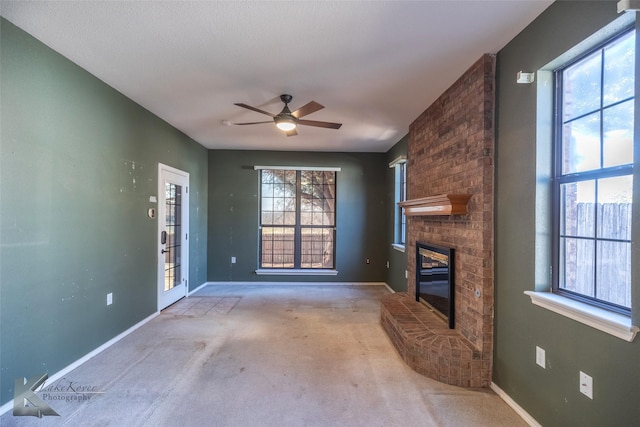 unfurnished living room with ceiling fan, light colored carpet, and a fireplace