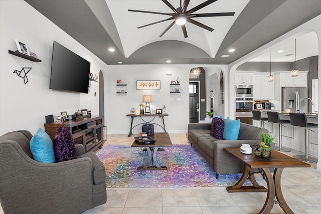 living room featuring arched walkways, light tile patterned flooring, recessed lighting, baseboards, and vaulted ceiling