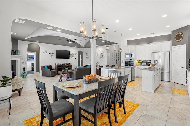 dining area with arched walkways, a fireplace, light tile patterned floors, recessed lighting, and a ceiling fan