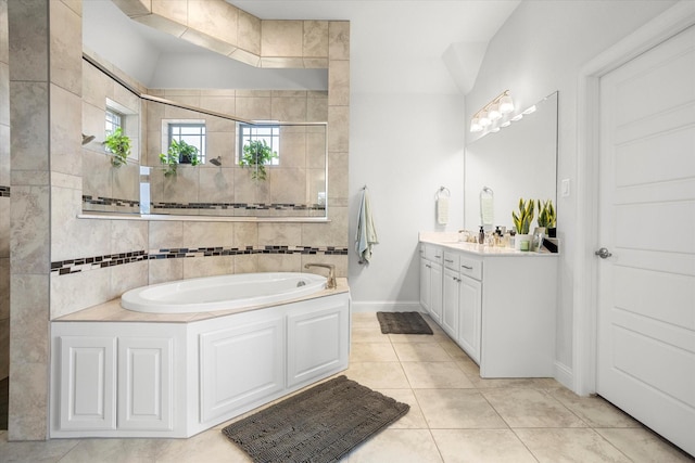 full bathroom featuring tile patterned flooring, a garden tub, vanity, and baseboards