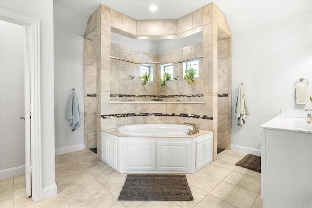 bathroom featuring tile patterned flooring, vanity, baseboards, a bath, and walk in shower