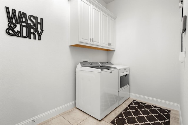 laundry area featuring cabinet space, independent washer and dryer, baseboards, and light tile patterned flooring