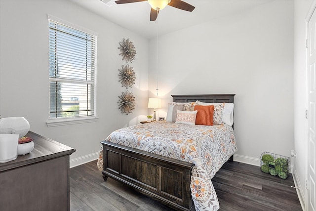 bedroom with dark wood-style floors, ceiling fan, and baseboards