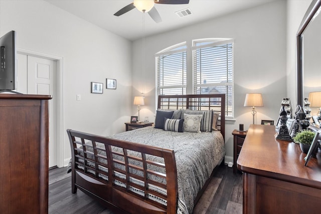 bedroom featuring ceiling fan, dark wood finished floors, visible vents, and baseboards