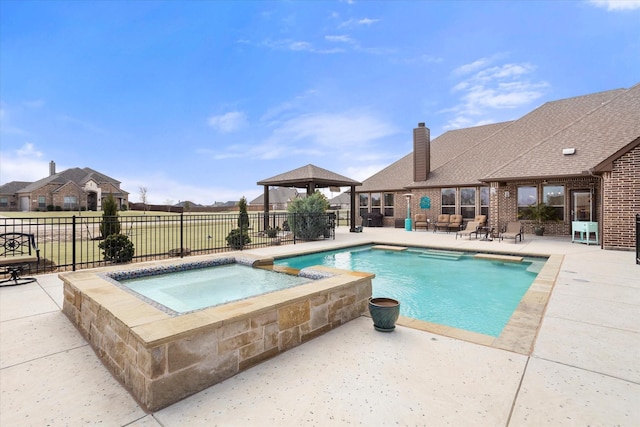 view of swimming pool with a patio area, a pool with connected hot tub, fence, and a gazebo