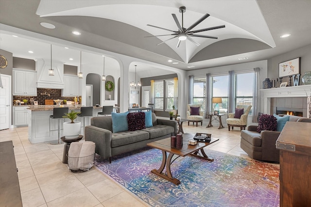 living room featuring lofted ceiling, a fireplace, light tile patterned flooring, and recessed lighting