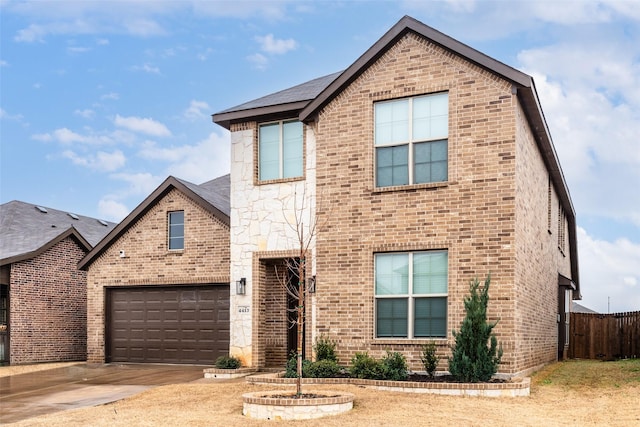 traditional home with a garage, driveway, brick siding, and fence