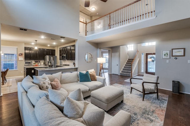 living room featuring dark wood-type flooring and a towering ceiling