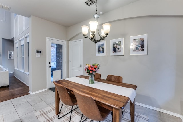 dining room featuring light tile patterned floors and a chandelier