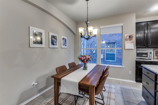 tiled dining room with an inviting chandelier