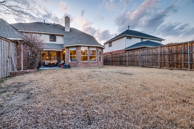 rear view of property featuring a patio and a lawn