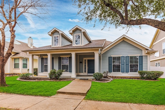 bungalow with a front yard and covered porch