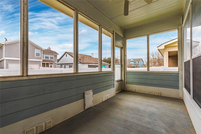 unfurnished sunroom with ceiling fan