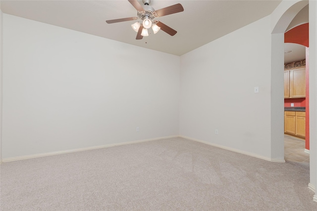 unfurnished room with light colored carpet and ceiling fan