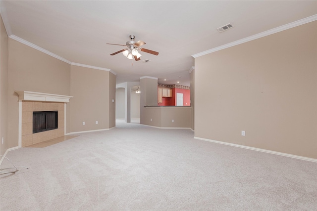 unfurnished living room with a tile fireplace, light carpet, ceiling fan, and crown molding