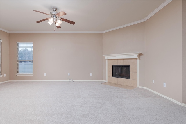 unfurnished living room featuring a tile fireplace, carpet floors, ceiling fan, and ornamental molding