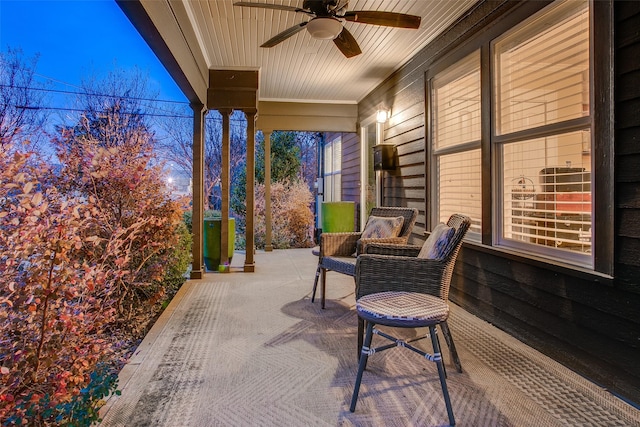 patio terrace at dusk featuring ceiling fan and covered porch