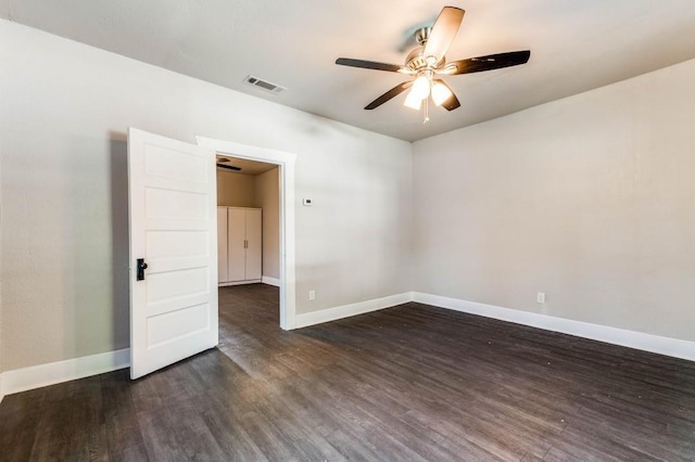 empty room with dark hardwood / wood-style flooring and ceiling fan