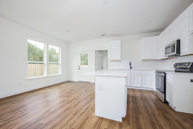 kitchen featuring white cabinetry, tasteful backsplash, stainless steel appliances, and a kitchen island