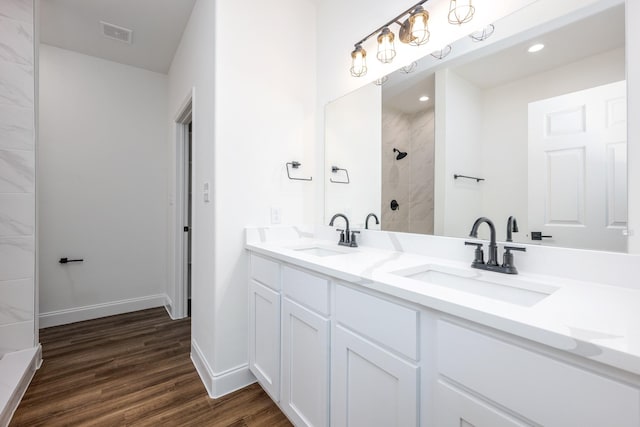 bathroom featuring vanity, hardwood / wood-style flooring, and tiled shower