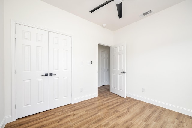 unfurnished bedroom featuring ceiling fan, light hardwood / wood-style floors, and a closet