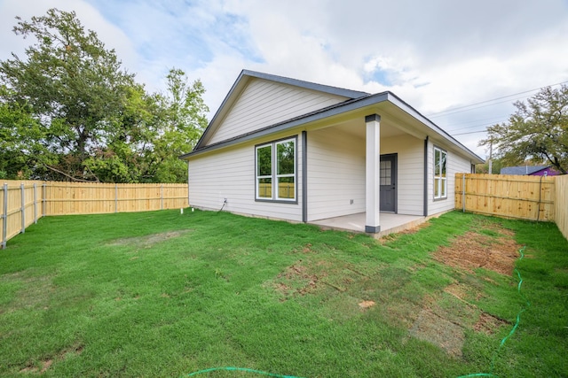 rear view of house featuring a patio and a lawn