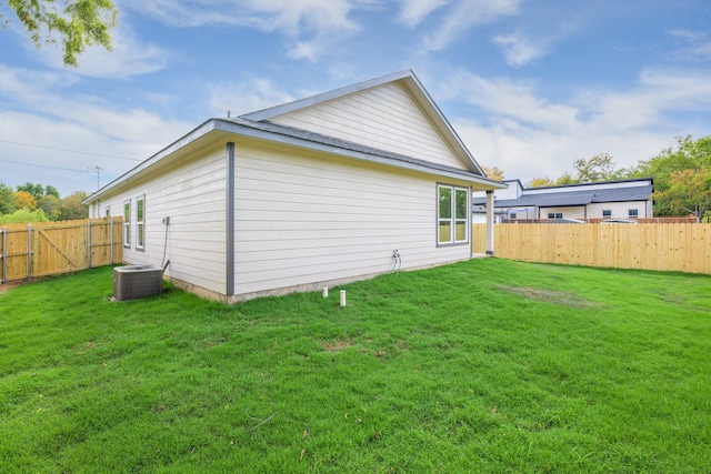 back of property featuring cooling unit and a yard