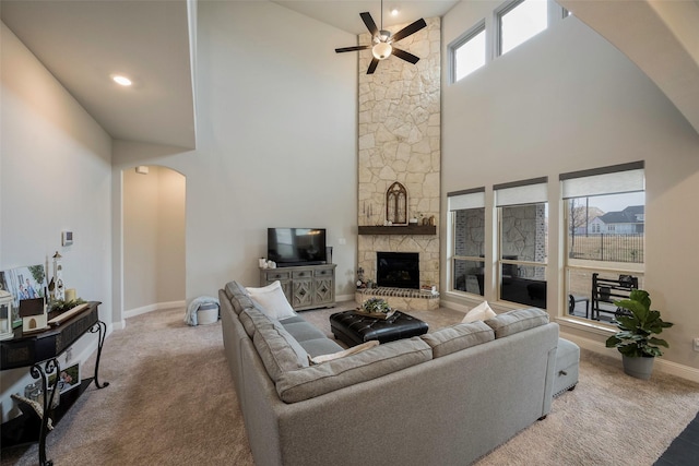 2402 Topaz Dr, Rockwall, TX 75087 - living room featuring a stone fireplace, carpet flooring, ceiling fan, and a towering ceiling