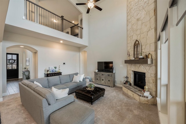 2402 Topaz Dr, Rockwall, TX 75087 - carpeted living room featuring a stone fireplace, a towering ceiling, and ceiling fan