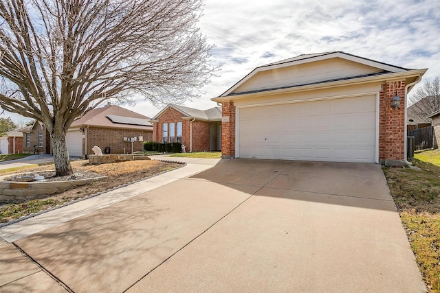 ranch-style house featuring a garage, brick siding, and driveway