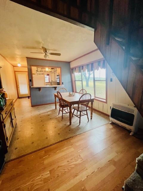 dining room featuring ceiling fan, ornamental molding, light hardwood / wood-style floors, and heating unit