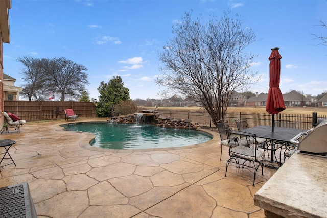 view of swimming pool featuring a patio area, outdoor dining space, a fenced in pool, and a fenced backyard