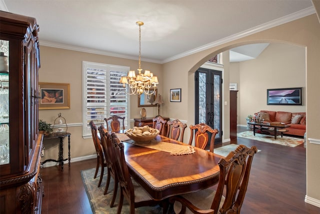 dining room featuring arched walkways, dark wood-style floors, a chandelier, and ornamental molding