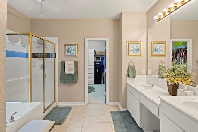 bathroom with tile patterned flooring, vanity, a stall shower, and a tub to relax in