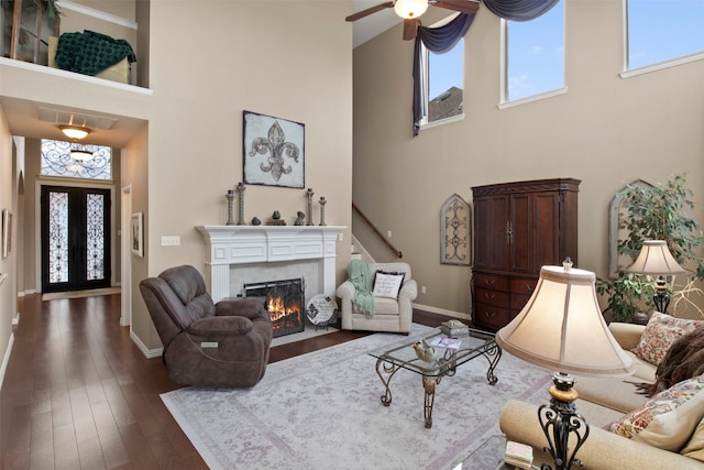 living room with baseboards, visible vents, dark wood finished floors, a tile fireplace, and french doors