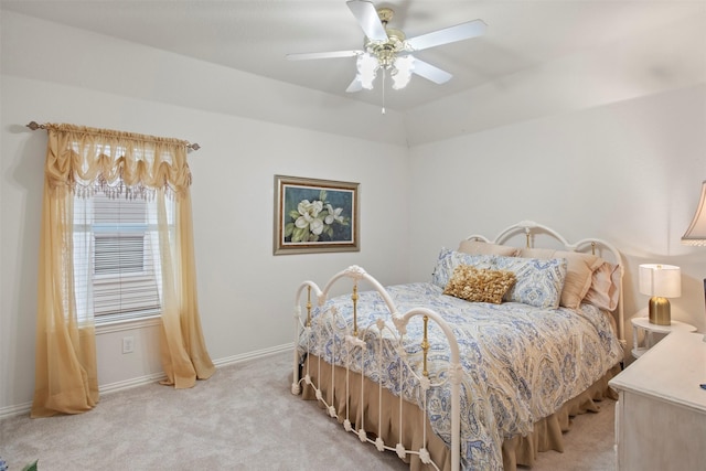 bedroom featuring light colored carpet, a ceiling fan, and baseboards