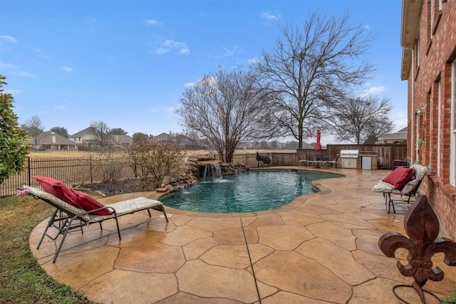 view of swimming pool with exterior kitchen, a fenced backyard, a fenced in pool, and a patio area