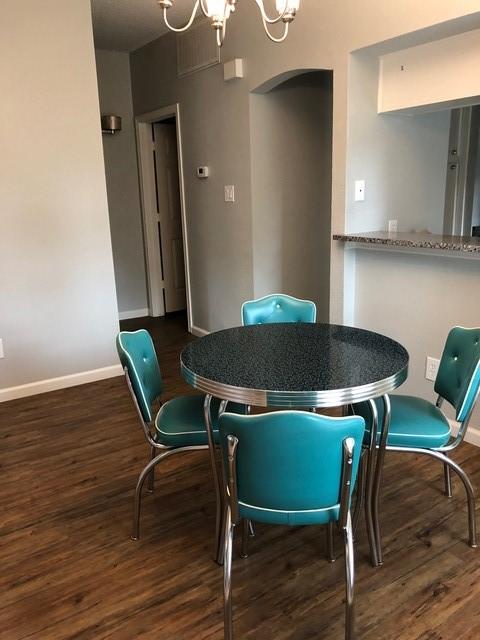 dining area featuring dark hardwood / wood-style flooring and a chandelier