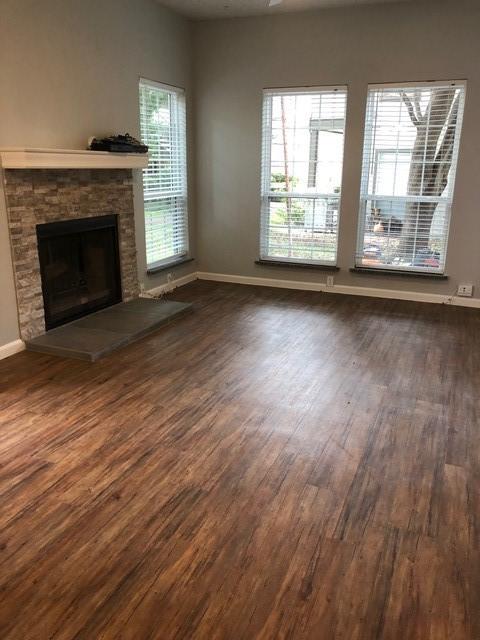 unfurnished living room featuring dark hardwood / wood-style floors and a fireplace