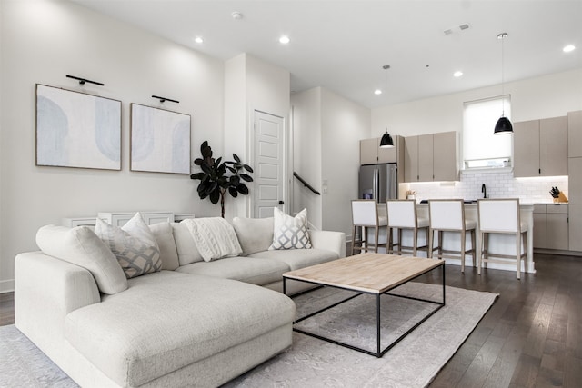 living room featuring dark hardwood / wood-style flooring and sink