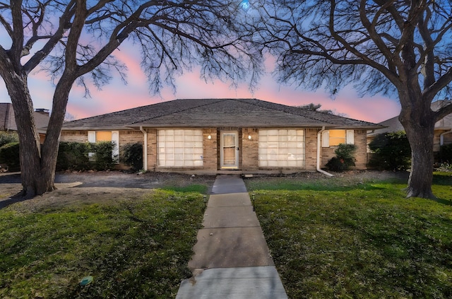 single story home featuring a lawn