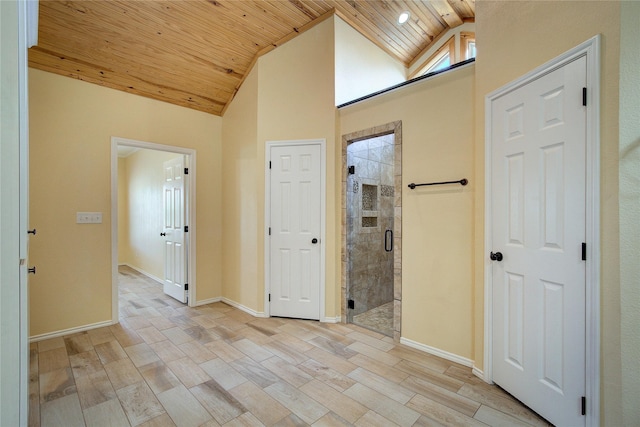 hallway with vaulted ceiling, wooden ceiling, and light hardwood / wood-style floors