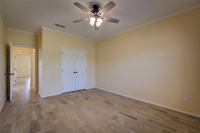 unfurnished bedroom with crown molding, light hardwood / wood-style floors, a closet, and ceiling fan