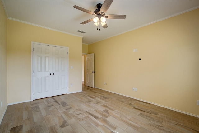 unfurnished bedroom featuring crown molding, a closet, ceiling fan, and light wood-type flooring