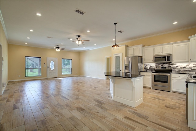 kitchen with decorative light fixtures, tasteful backsplash, white cabinetry, a center island, and stainless steel appliances