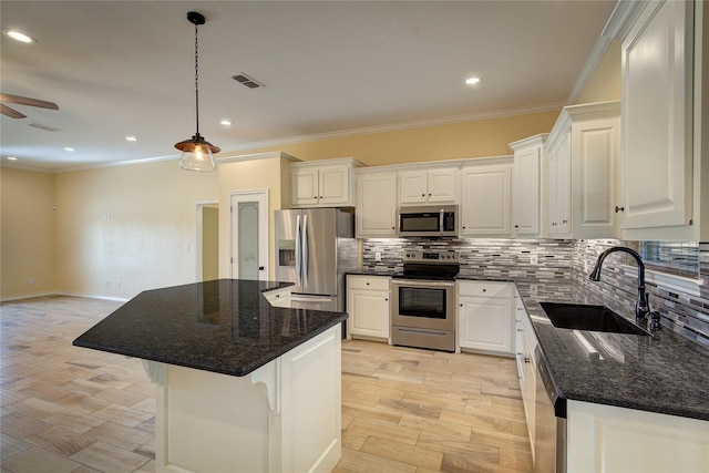 kitchen with sink, a center island, hanging light fixtures, appliances with stainless steel finishes, and white cabinets