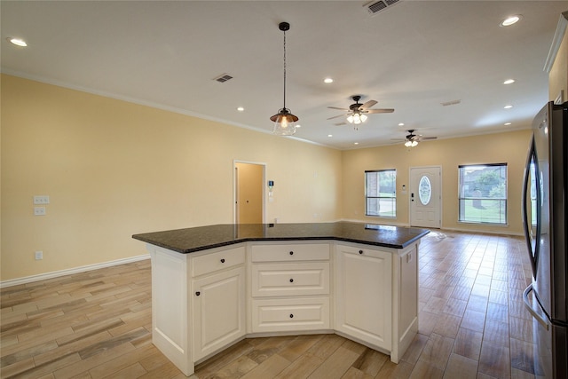 kitchen featuring white cabinetry, a center island, stainless steel refrigerator, pendant lighting, and light hardwood / wood-style floors