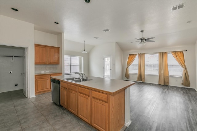 kitchen with sink, stainless steel dishwasher, an island with sink, pendant lighting, and decorative backsplash