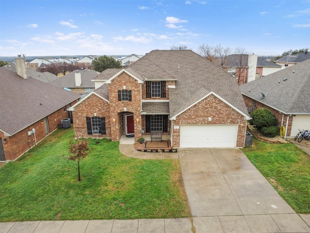 traditional-style home with brick siding, a shingled roof, an attached garage, driveway, and a front lawn