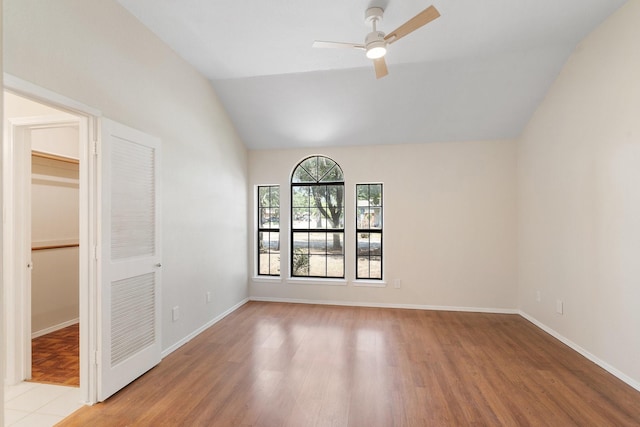 unfurnished room with lofted ceiling, ceiling fan, and light hardwood / wood-style flooring